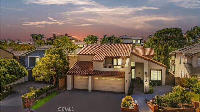 28161 Haria, Mission Viejo, CA 92692 - view of front of house with stucco siding, asphalt driveway, a garage, a balcony, and a residential view