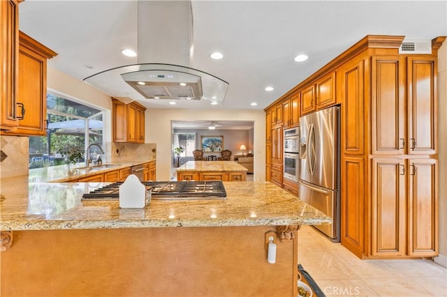 28161 Haria, Mission Viejo, CA 92692 - kitchen featuring appliances with stainless steel finishes, a peninsula, light stone counters, tasteful backsplash, and island exhaust hood