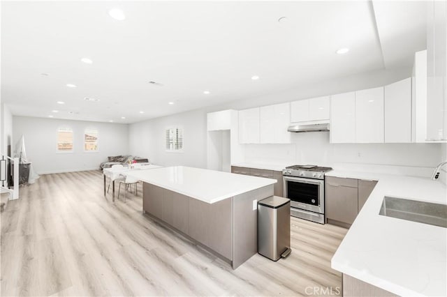 1359 Point Loma Pl, Walnut, CA 91789 - kitchen with stainless steel gas range, under cabinet range hood, modern cabinets, a center island, and recessed lighting