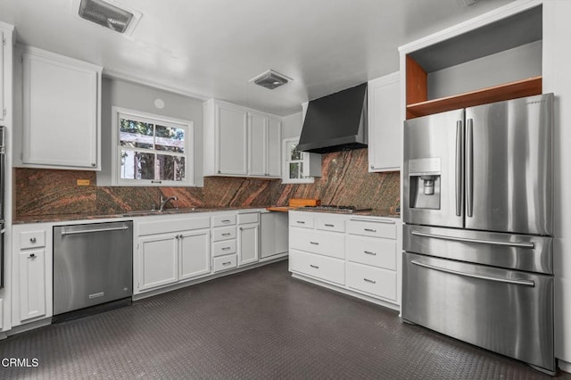 664 Monterey Rd, South Pasadena, CA 91030 - kitchen featuring appliances with stainless steel finishes, wall chimney range hood, white cabinetry, and backsplash