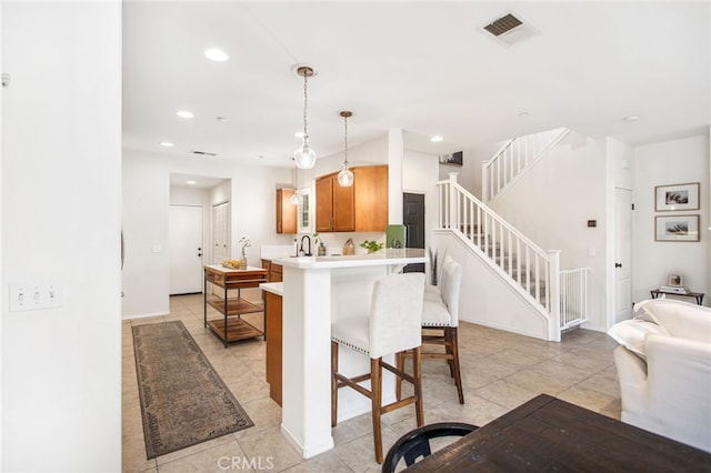 36287 Grazia Way, Winchester, CA 92596 - kitchen featuring a breakfast bar area, open floor plan, light countertops, a peninsula, and light tile patterned flooring