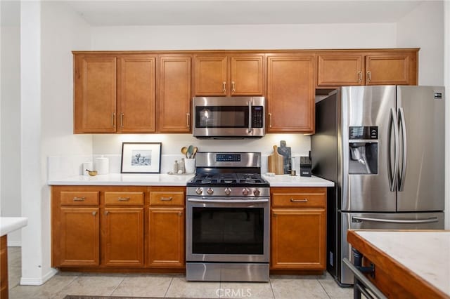 36287 Grazia Way, Winchester, CA 92596 - kitchen featuring stainless steel appliances, light countertops, brown cabinets, and light tile patterned floors