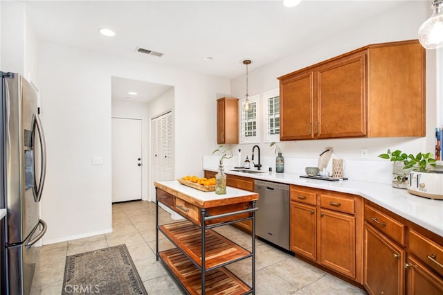 36287 Grazia Way, Winchester, CA 92596 - kitchen featuring stainless steel appliances, light countertops, hanging light fixtures, brown cabinetry, and recessed lighting
