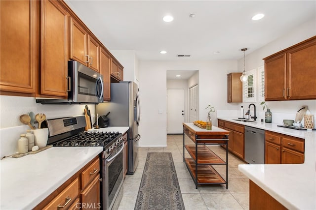 36287 Grazia Way, Winchester, CA 92596 - kitchen featuring stainless steel appliances, brown cabinetry, light countertops, hanging light fixtures, and recessed lighting
