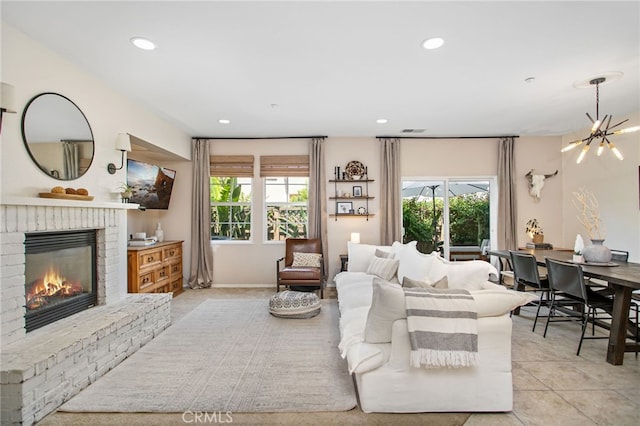 36287 Grazia Way, Winchester, CA 92596 - living room featuring a brick fireplace, light tile patterned floors, recessed lighting, and a chandelier