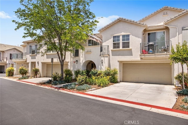 36287 Grazia Way, Winchester, CA 92596 - view of front of property with a balcony, an attached garage, stucco siding, concrete driveway, and a tiled roof
