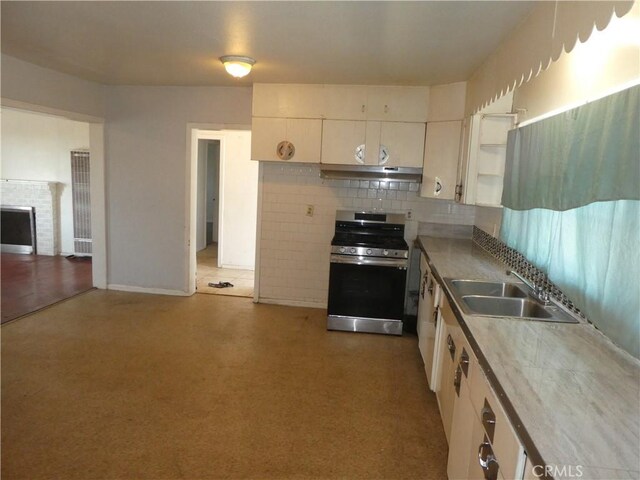5528 San Onofre Ter, San Diego, CA 92114 - kitchen with stainless steel range with gas stovetop, under cabinet range hood, tasteful backsplash, white cabinets, and open shelves