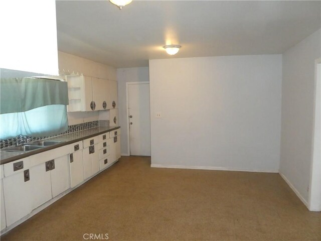 5528 San Onofre Ter, San Diego, CA 92114 - kitchen featuring dark countertops, light carpet, white cabinetry, and open shelves