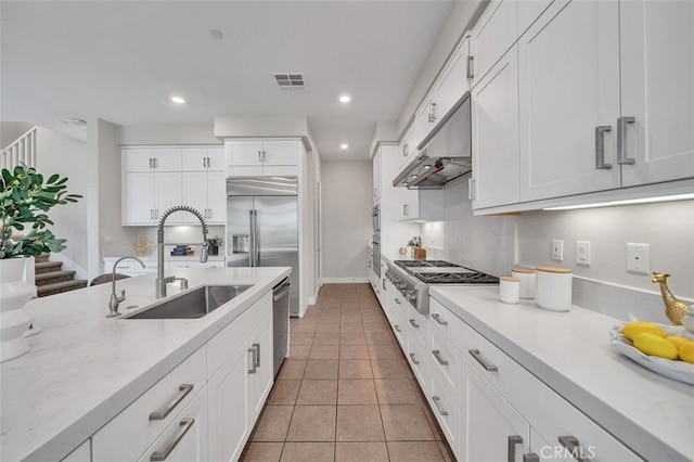 319 Sawbuck, Irvine, CA 92618 - kitchen with stainless steel appliances, under cabinet range hood, white cabinets, recessed lighting, and light tile patterned flooring