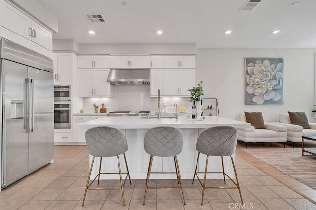 319 Sawbuck, Irvine, CA 92618 - kitchen with stainless steel appliances, under cabinet range hood, light tile patterned flooring, light countertops, and recessed lighting