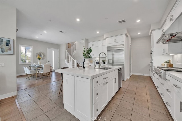 319 Sawbuck, Irvine, CA 92618 - kitchen featuring stainless steel appliances, under cabinet range hood, light countertops, recessed lighting, and a kitchen island with sink