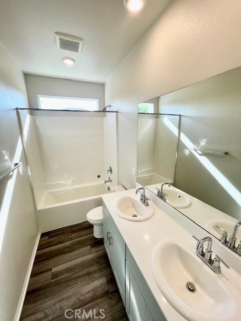 24612 Hero Cir, Menifee, CA 92584 - bathroom featuring bathtub / shower combination, double vanity, and wood finished floors