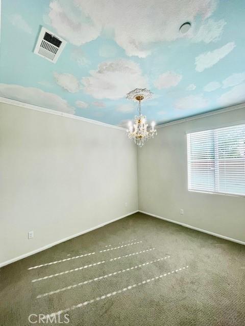 24612 Hero Cir, Menifee, CA 92584 - empty room with ornamental molding, a chandelier, and carpet floors