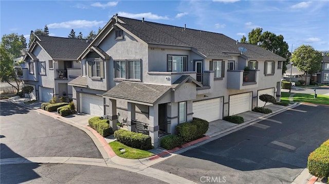 3434 E Lambeth Ct Unit F, Orange, CA 92869 - townhome / multi-family property featuring an attached garage, stucco siding, driveway, and a residential view