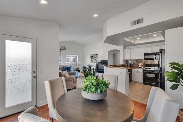 3434 E Lambeth Ct Unit F, Orange, CA 92869 - dining area featuring recessed lighting, vaulted ceiling, arched walkways, and light wood-style floors