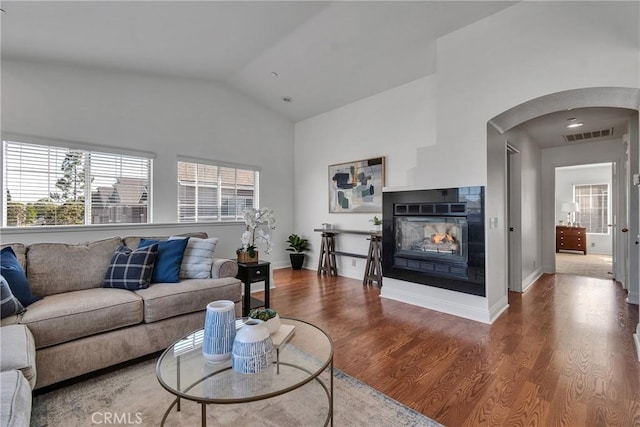 3434 E Lambeth Ct Unit F, Orange, CA 92869 - living area featuring vaulted ceiling, wood finished floors, arched walkways, and a multi sided fireplace