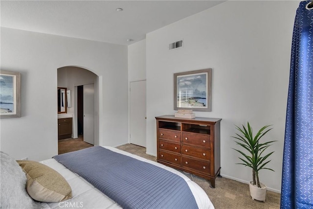 3434 E Lambeth Ct Unit F, Orange, CA 92869 - bedroom with arched walkways, carpet floors, and ensuite bathroom