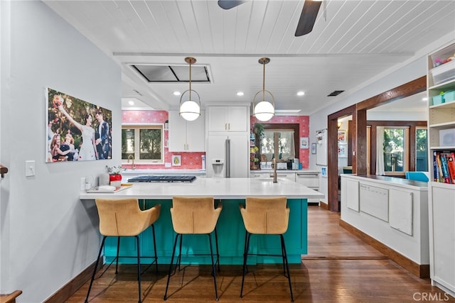 1719 Monte Vista St, Pasadena, CA 91106 - kitchen featuring stainless steel gas cooktop, light countertops, dark wood-type flooring, white cabinets, and a peninsula