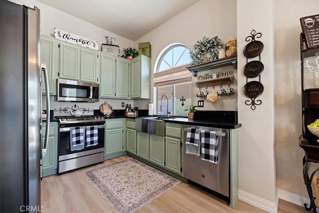 5129 W Pinehurst Dr, Banning, CA 92220 - kitchen featuring stainless steel appliances, green cabinets, light wood-style flooring, lofted ceiling, and dark countertops