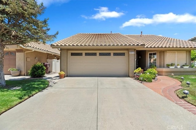 5129 W Pinehurst Dr, Banning, CA 92220 - view of front of home with an attached garage, concrete driveway, a tiled roof, and stucco siding