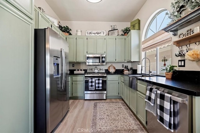 5129 W Pinehurst Dr, Banning, CA 92220 - kitchen with stainless steel appliances, green cabinets, dark countertops, light wood-style flooring, and lofted ceiling