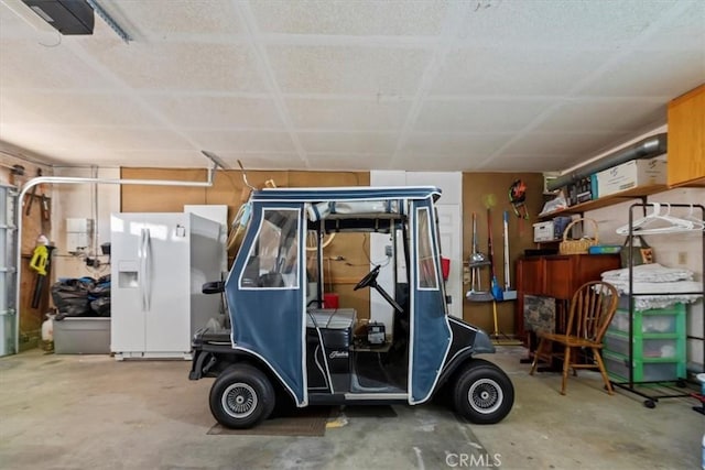 5129 W Pinehurst Dr, Banning, CA 92220 - garage with white refrigerator with ice dispenser and a garage door opener