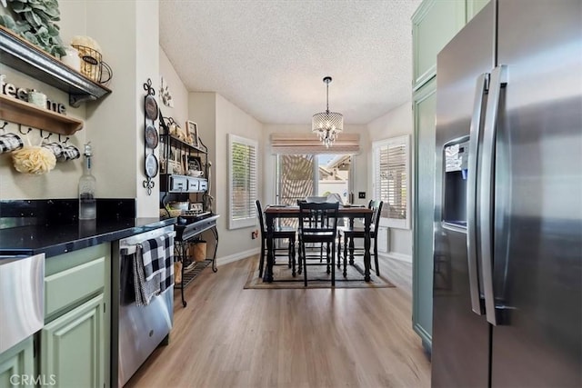 5129 W Pinehurst Dr, Banning, CA 92220 - kitchen featuring appliances with stainless steel finishes, green cabinets, light wood finished floors, a textured ceiling, and dark countertops