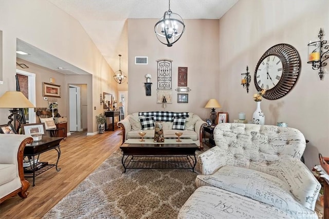 5129 W Pinehurst Dr, Banning, CA 92220 - living room featuring wood finished floors, high vaulted ceiling, and a chandelier