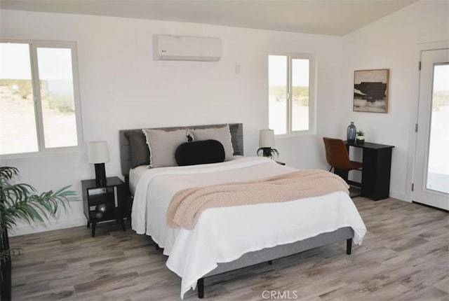 55354 El Lobo Rd, Landers, CA 92285 - bedroom featuring a wall mounted air conditioner, wood finished floors, multiple windows, and lofted ceiling