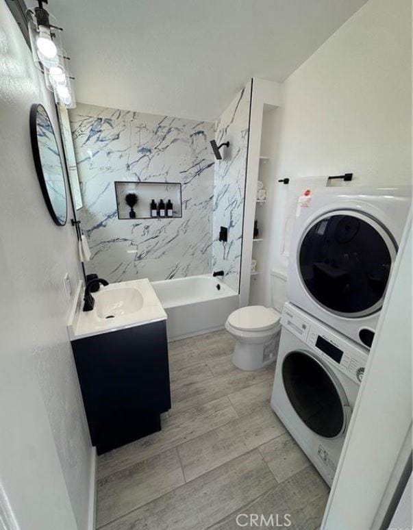 55354 El Lobo Rd, Landers, CA 92285 - full bathroom with stacked washer and clothes dryer, vanity, washtub / shower combination, and wood finished floors