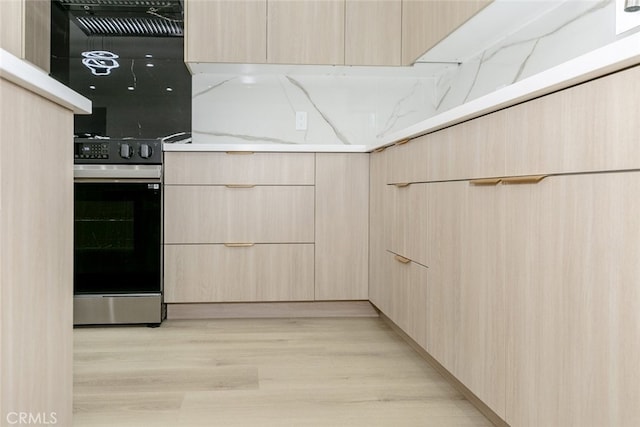 15009 Wyandotte St, Van Nuys, CA 91405 - kitchen featuring light brown cabinetry, modern cabinets, light wood finished floors, light stone counters, and range with electric cooktop