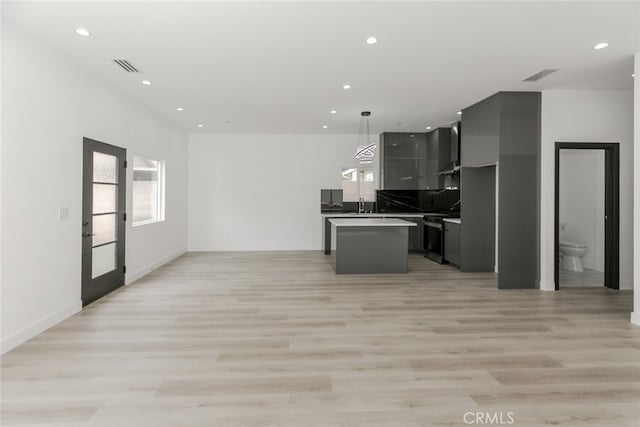 15009 Wyandotte St, Van Nuys, CA 91405 - kitchen with open floor plan, a kitchen island, light wood-type flooring, recessed lighting, and range