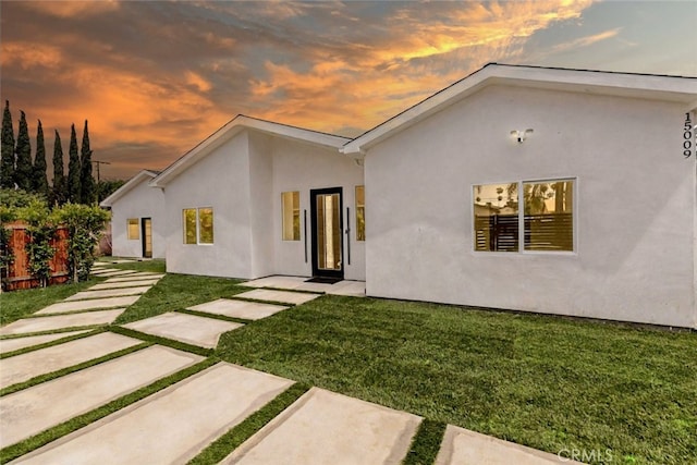 15009 Wyandotte St, Van Nuys, CA 91405 - back of property at dusk with a lawn and stucco siding