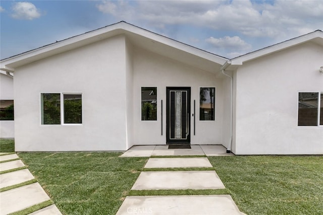 15009 Wyandotte St, Van Nuys, CA 91405 - view of exterior entry featuring stucco siding and a lawn