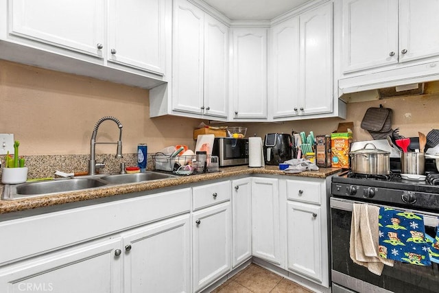 23277 Maribel Ave, Carson, CA 90745 - kitchen with stainless steel range with gas stovetop, white cabinets, under cabinet range hood, light tile patterned floors, and light countertops