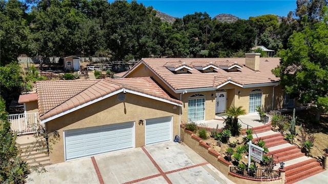 9733 Kentland Ave, Chatsworth, CA 91311 - ranch-style home with driveway, stucco siding, a tiled roof, and a chimney