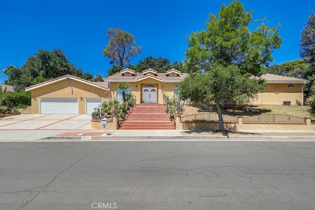 9733 Kentland Ave, Chatsworth, CA 91311 - view of front of house featuring stucco siding, a garage, concrete driveway, and a tiled roof