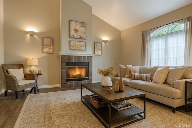 9733 Kentland Ave, Chatsworth, CA 91311 - living room with wood finished floors, a tiled fireplace, and high vaulted ceiling