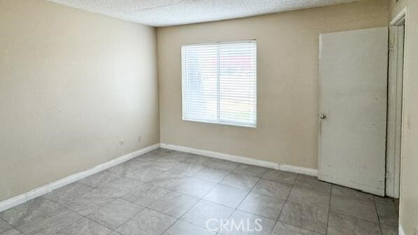 1735 E Washington St, Colton, CA 92324 - unfurnished room with a textured ceiling and baseboards