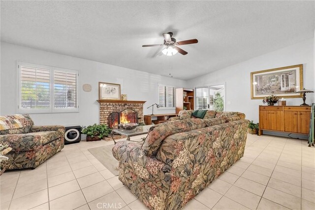 25270 Tradewinds Dr, Menifee, CA 92585 - living room featuring a ceiling fan, light tile patterned floors, a fireplace, and a textured ceiling