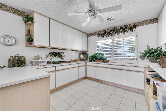 25270 Tradewinds Dr, Menifee, CA 92585 - kitchen featuring a ceiling fan, a textured ceiling, light countertops, and white cabinetry