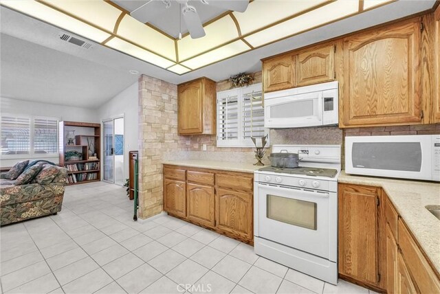 25270 Tradewinds Dr, Menifee, CA 92585 - kitchen with white appliances, lofted ceiling, light countertops, light tile patterned floors, and open floor plan
