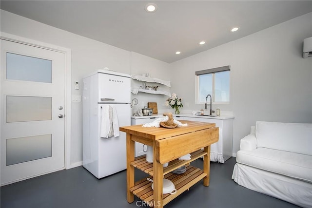 2250 Delgada Ave, Landers, CA 92285 - kitchen with freestanding refrigerator, finished concrete floors, light countertops, white cabinetry, and recessed lighting
