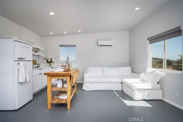 2250 Delgada Ave, Landers, CA 92285 - living room with a wall unit AC, recessed lighting, and concrete floors