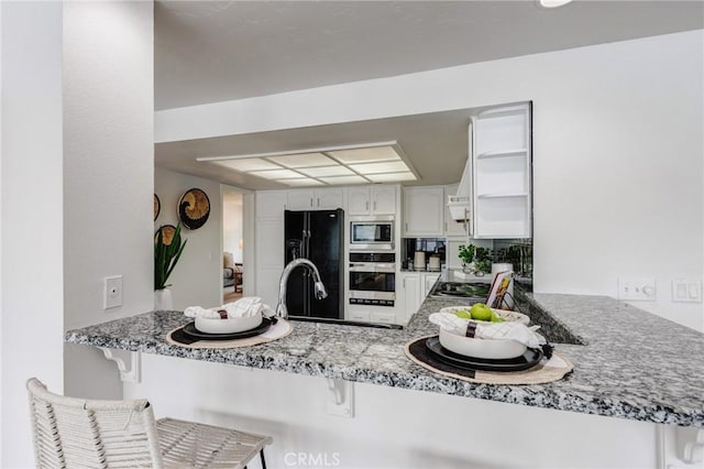 42768 Santa Suzanne Pl, Temecula, CA 92592 - kitchen featuring stainless steel appliances, a peninsula, a kitchen bar, and white cabinetry