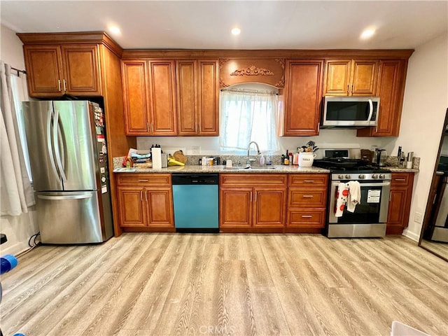 3238 Prospect Ave, La Crescenta, CA 91214 - kitchen featuring appliances with stainless steel finishes, brown cabinetry, light wood finished floors, light stone counters, and recessed lighting