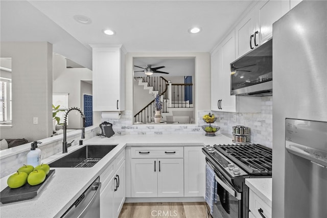 1519 San Rafael Pl, Corona, CA 92882 - kitchen with appliances with stainless steel finishes, a ceiling fan, tasteful backsplash, white cabinets, and light wood-type flooring