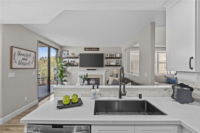 1519 San Rafael Pl, Corona, CA 92882 - kitchen featuring open floor plan, white cabinetry, a glass covered fireplace, and healthy amount of natural light