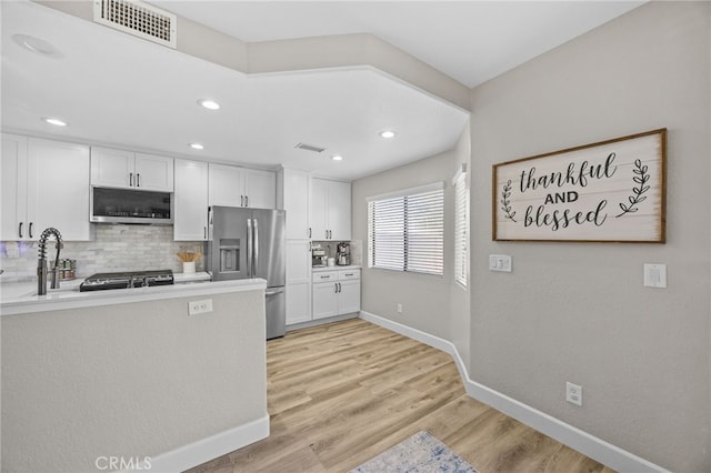 1519 San Rafael Pl, Corona, CA 92882 - kitchen featuring appliances with stainless steel finishes, decorative backsplash, white cabinets, light wood-type flooring, and light countertops