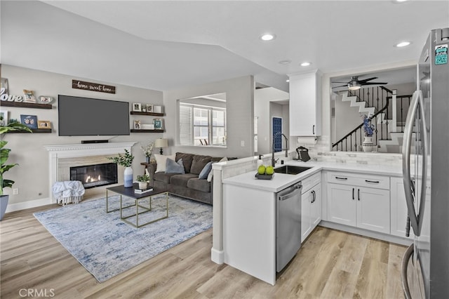 1519 San Rafael Pl, Corona, CA 92882 - kitchen with appliances with stainless steel finishes, white cabinets, open floor plan, light wood finished floors, and recessed lighting